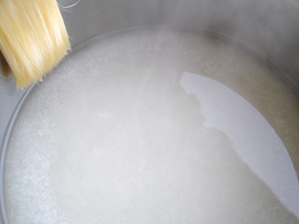 brushing sugar crystals from the pan